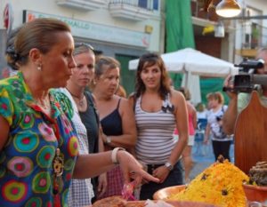 la alcaldesa con varios de los miembros de su equipo de gobierno se interesa por los productos que se ofrecen al visitante en este Mercado Marinero