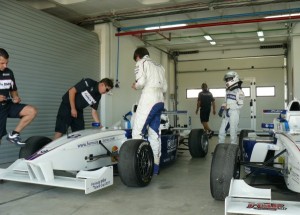 Pilotos ante sus coches en el circuito de Monteblanco.