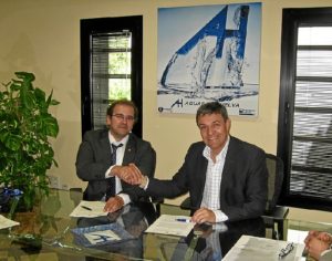 El director de Cáritas y el gerente de Aguas de Huelva estrechan la mano tras rubricar el acuerdo.