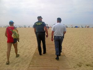 Efectivos de las fuerzas de seguridad patrullan por una playa.