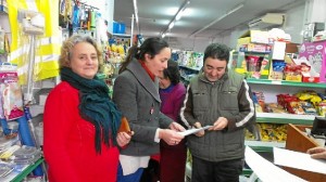 Rebeca Martin, en el centro, recoge firmas en un establecimiento comercial de Cortegana