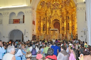 Interior de la ermita, con cientos de personas rezándole a la Virgen.