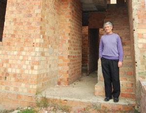 Juan Maestre junto a la casa paralizada por problemas desde 2003.