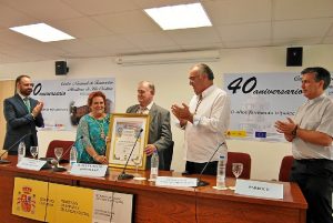 Antonia Grao le entrega un pergamino recordatorio al homenajeado